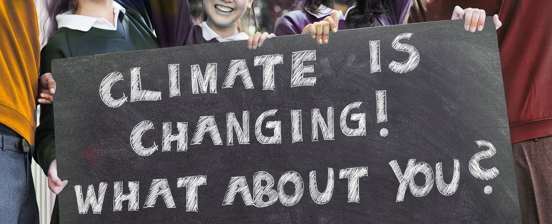 Die Abbildung zeigt junge Menschen, die ein Schild halten, auf dem steht “Climate ist Changing! What about you?“